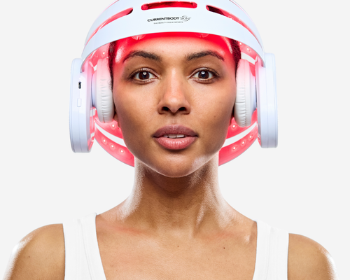 Woman using CurrentBody LED Hair Growth Helmet on her head